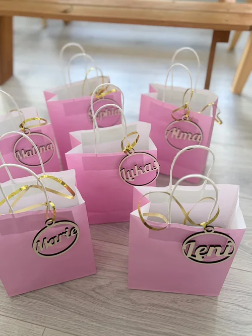 Personalisierte Holz-Namensanhänger an rosa Geschenktüten