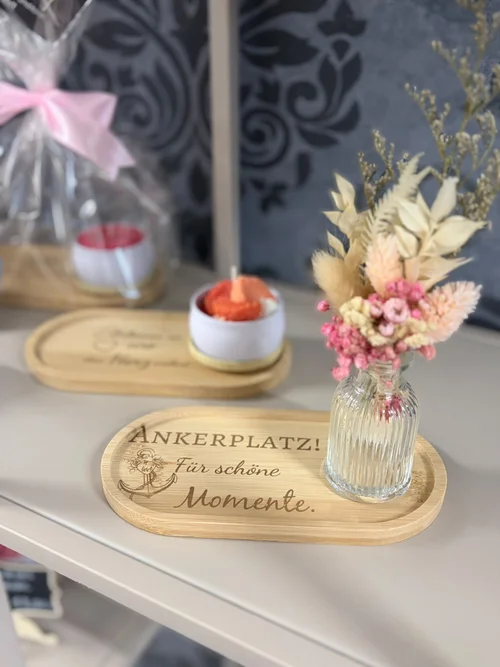 Tablett aus Holz mit Gravur "Ankerplatz! Für schöne Momente." mit Kerze und Trockenblumen-Vase in Nahaufnahme